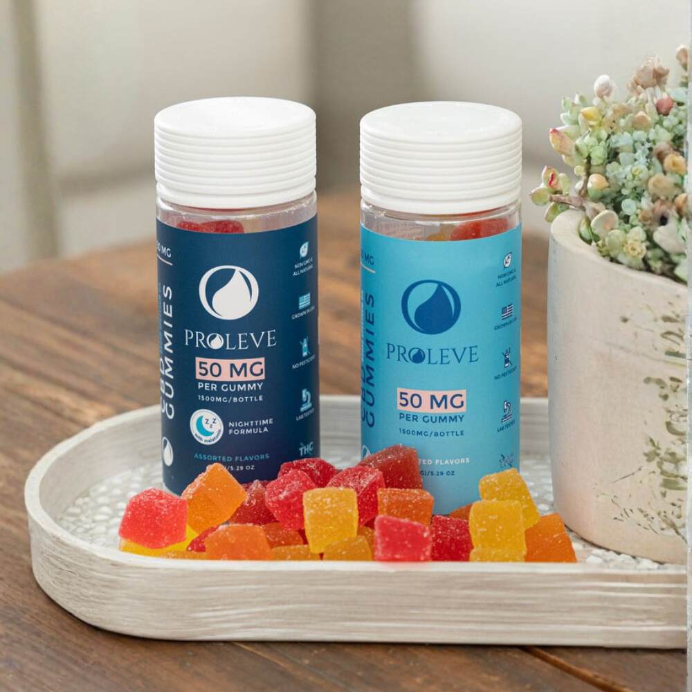 Two containers of Proleve gummies on a wooden surface with a decorative plant in the background.