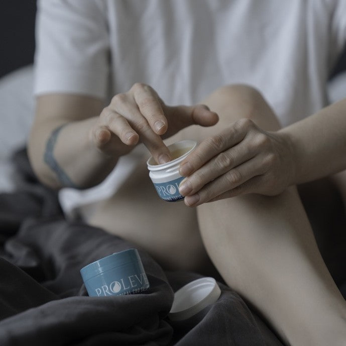 Person applying CBD salve to their leg.